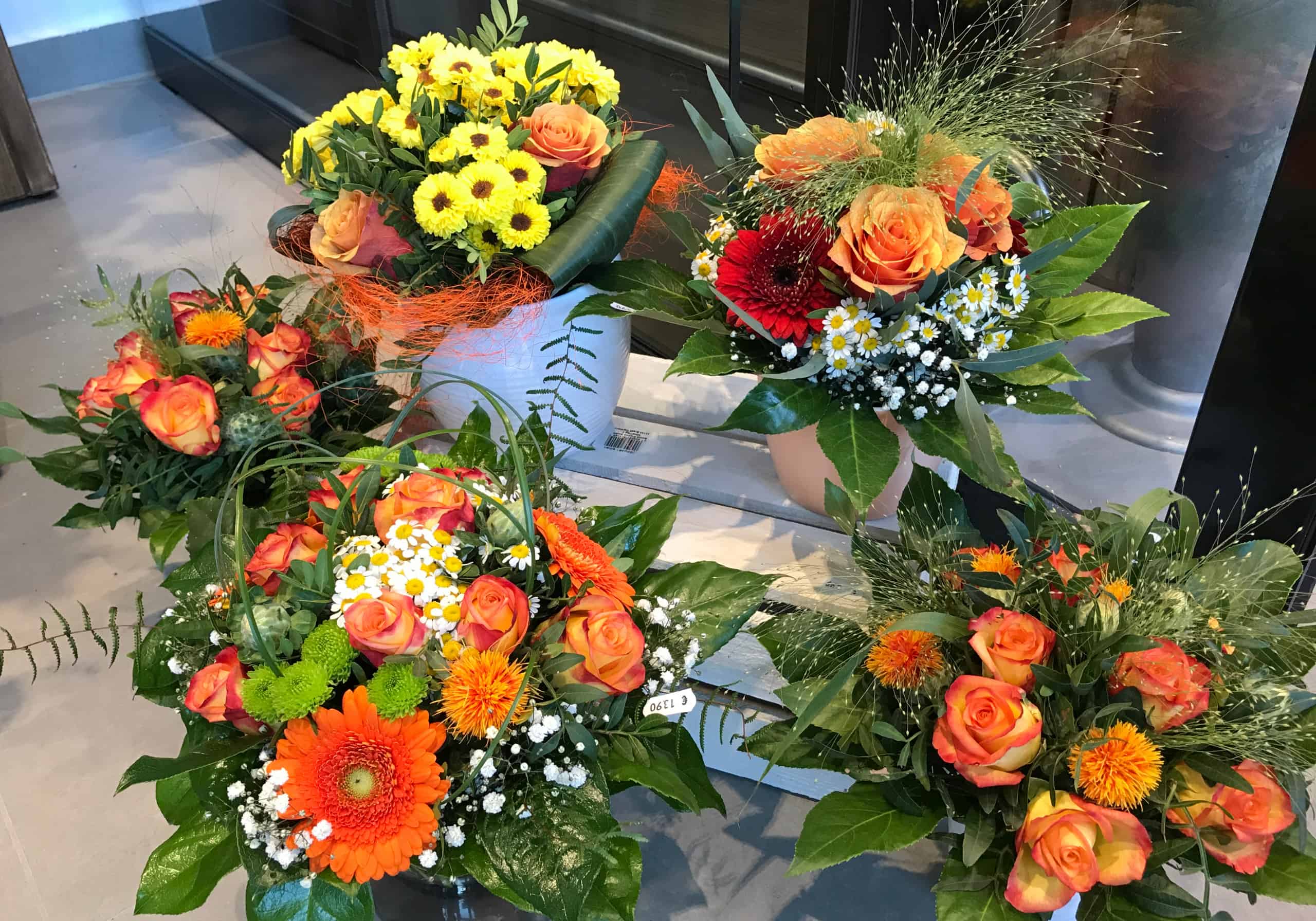 Fünf verschieden gebundene Blumensträuße in orange Tönen